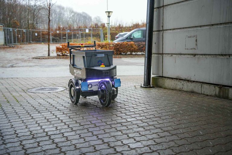 Logistics robot with box on top driving outside