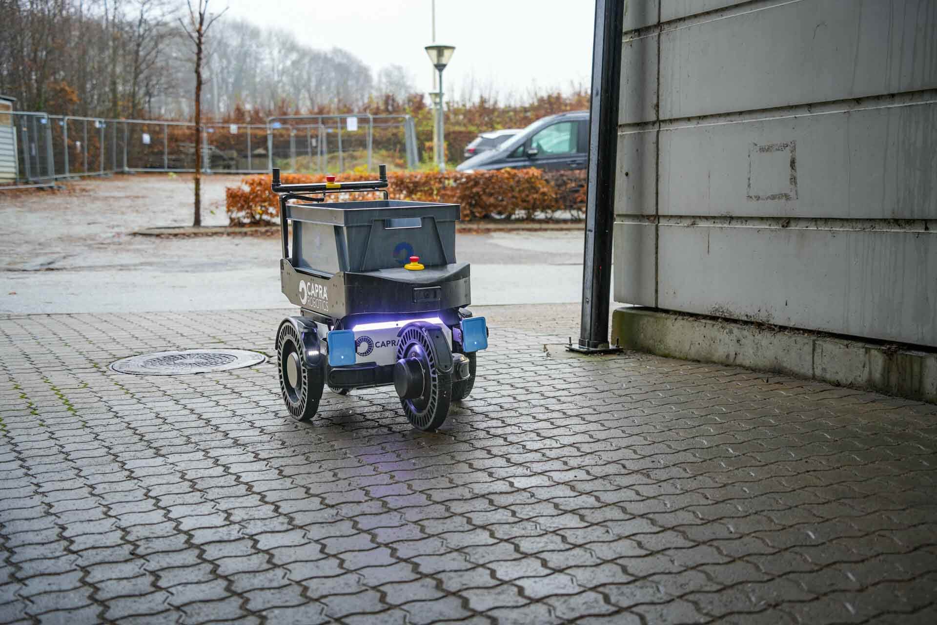 Logistics robot with box on top driving outside