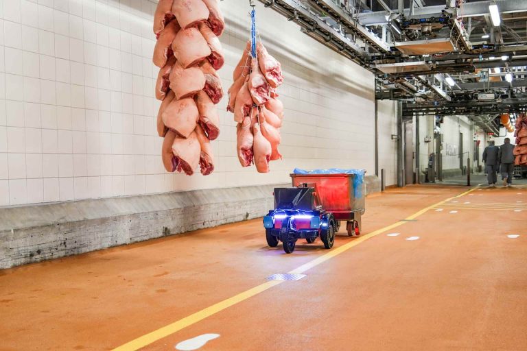 logistics robot with trailer driving through slaughterhouse hall