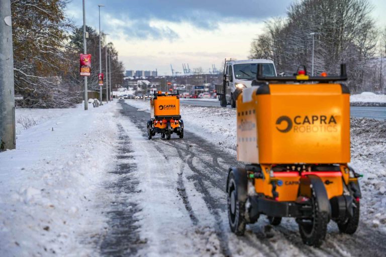 two deicing robots driving by snowy road