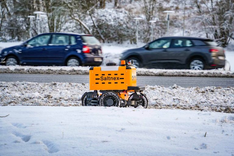 a deicing robot driving by snowy road